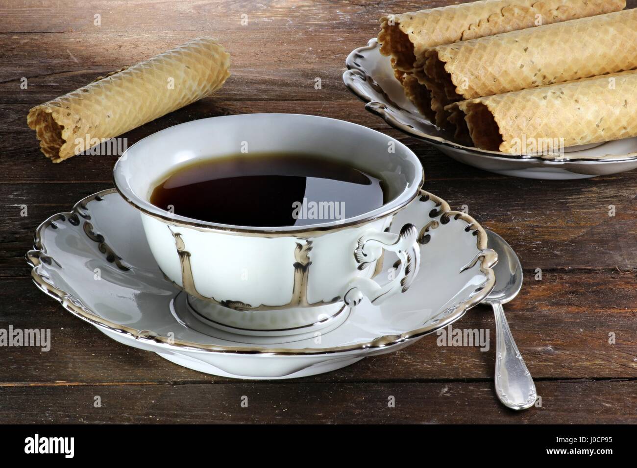 black tea served with traditional East Frisian New Year waffles in a beautiful ancient cup of the mid 19th century Stock Photo