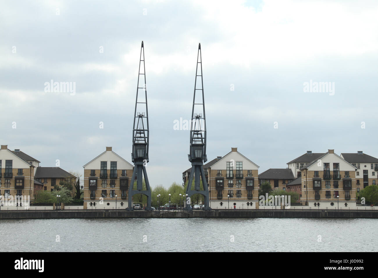 London, UK. 12th Apr, 2017. London, United Kingdom - April 12: Cranes and residential houses at the Royal Victoria in East London. The Royal Victoria Dock was the largest of three docks in the Royal Docks of east London, now part of the redeveloped Docklands. Credit: David Mbiyu/Alamy Live News Stock Photo