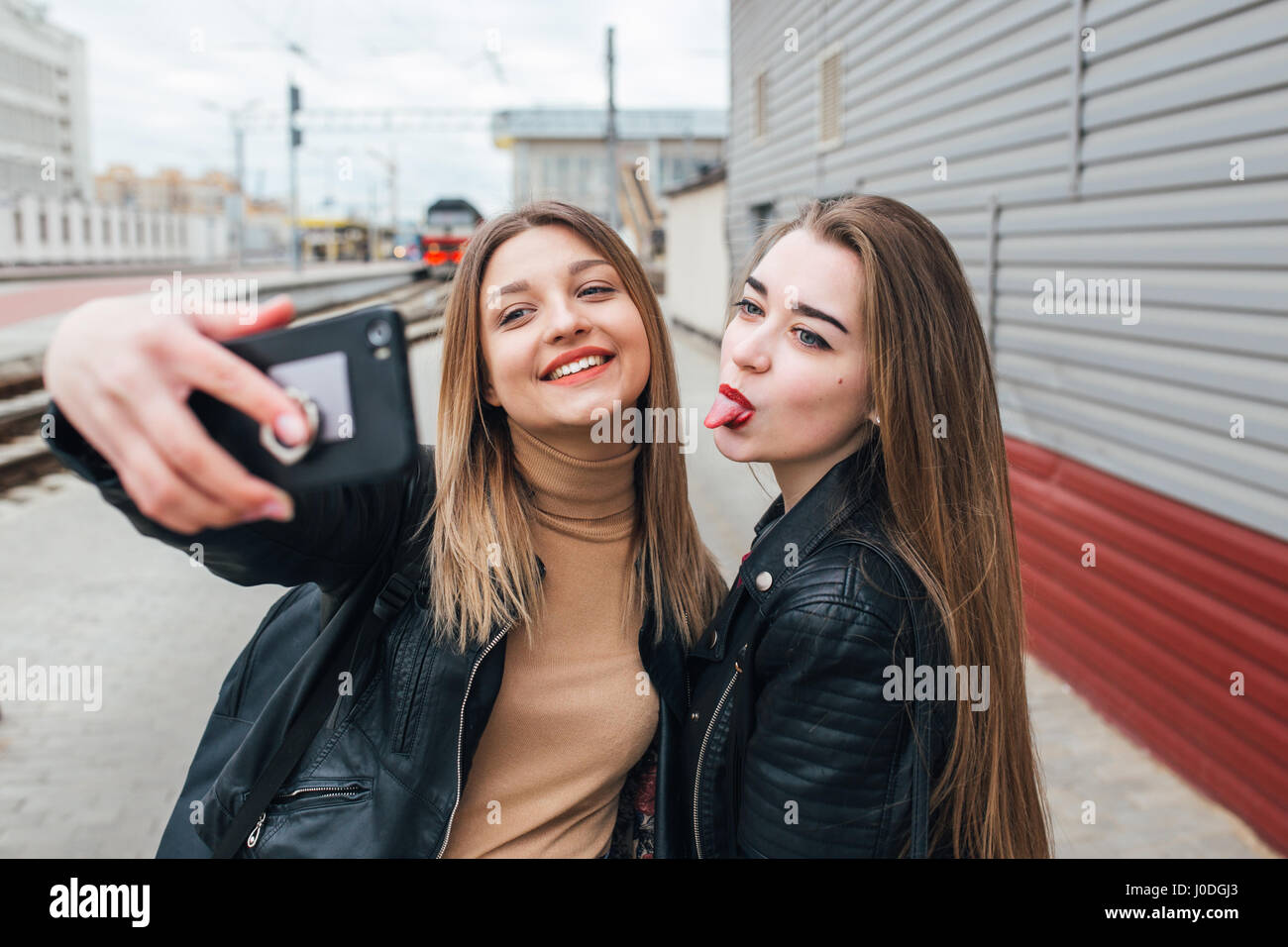 Two young girls taking selfie using smartphone Stock Photo