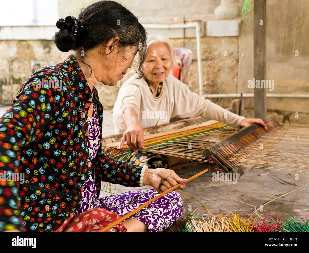 Horizontal portrait of old ladies weaving traditional Vietnamese
