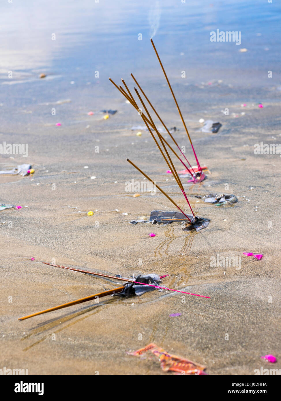 Vertical view of incense sticks smoldering in the sand in Da Nang, Vietnam Stock Photo