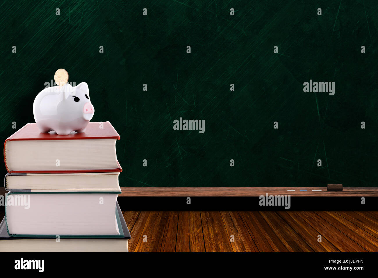 Piggy bank with coin on a stack of books on chalkboard background and ...