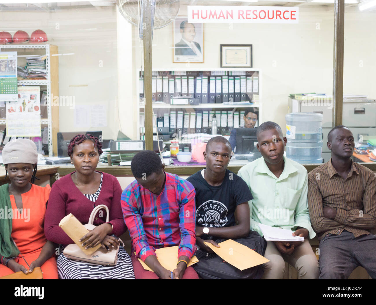 Job applicants wait with their paperwork after interviewing for jobs at
