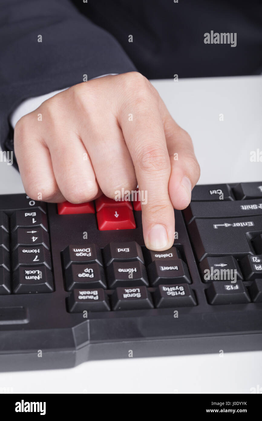 finger pushing delete button on a keyboard of computer Stock Photo