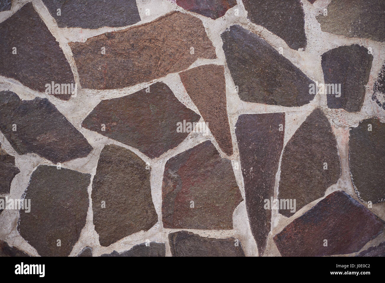 Brown stone floor background. Plane rocks with cement in wall Stock Photo