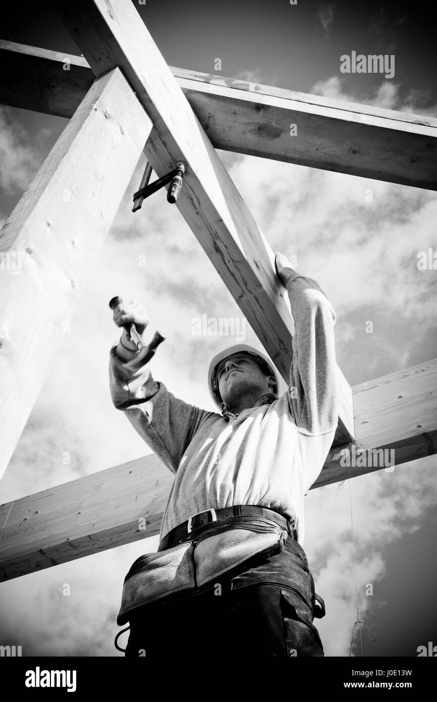 construction worker at work with winch on roof construction Stock Photo