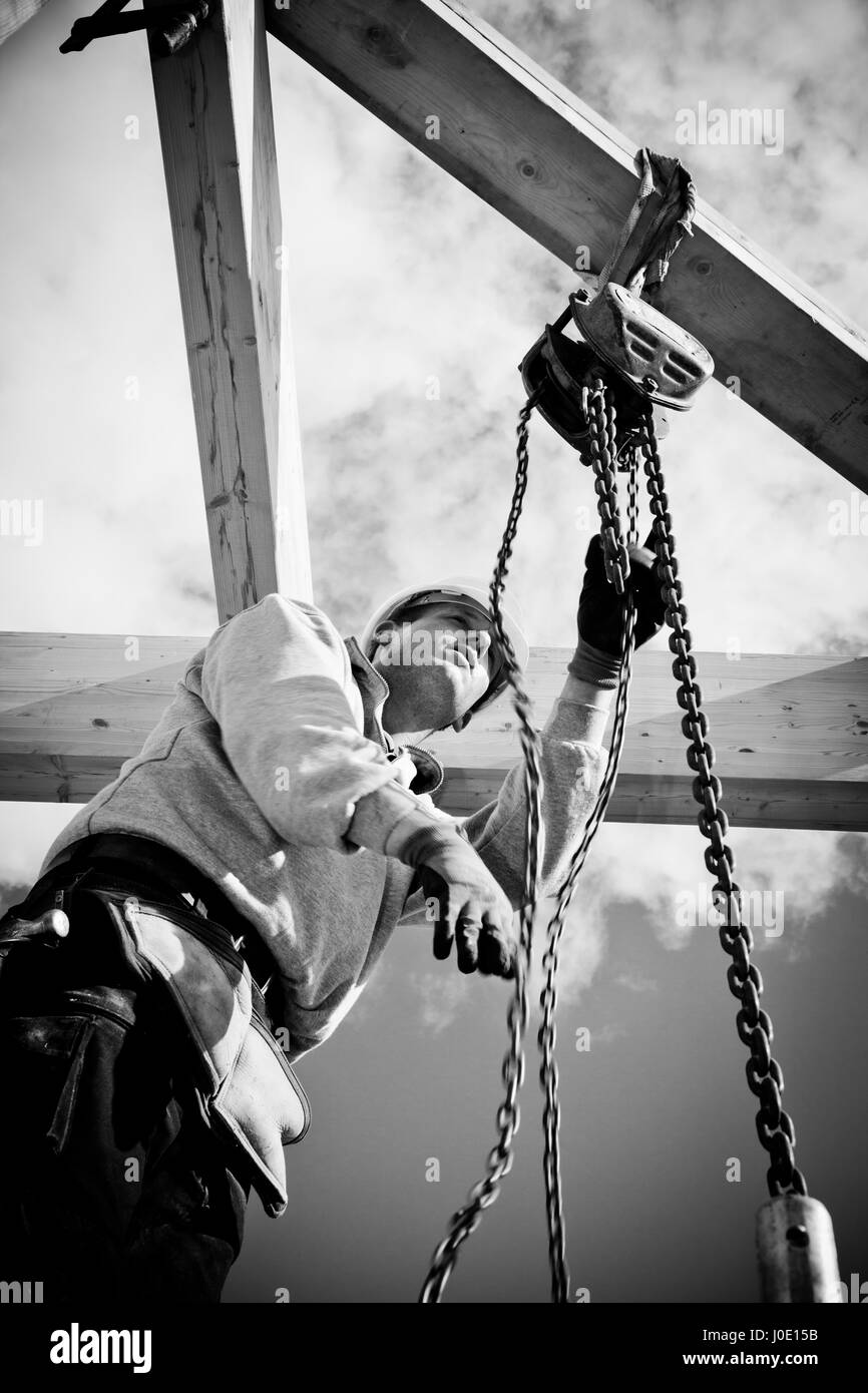 construction worker at work with winch on roof construction.Monochrome