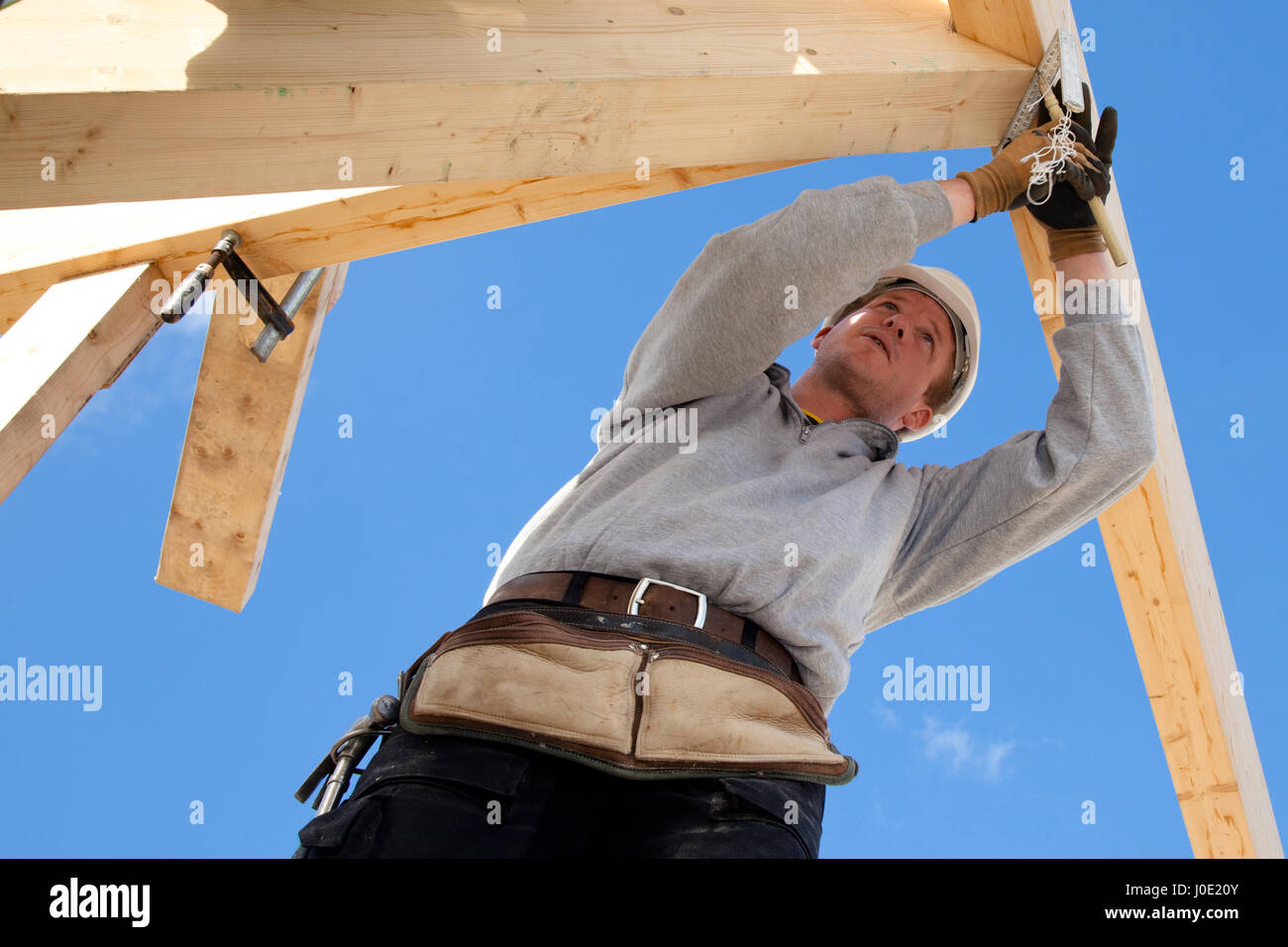 carpenter at work with wooden roof construction Stock Photo - Alamy