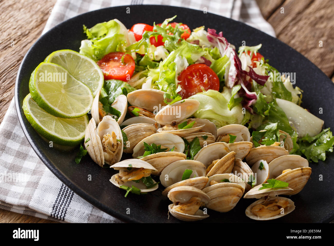 Shellfish with herbs and a mix of vegetable salad close-up on a plate ...