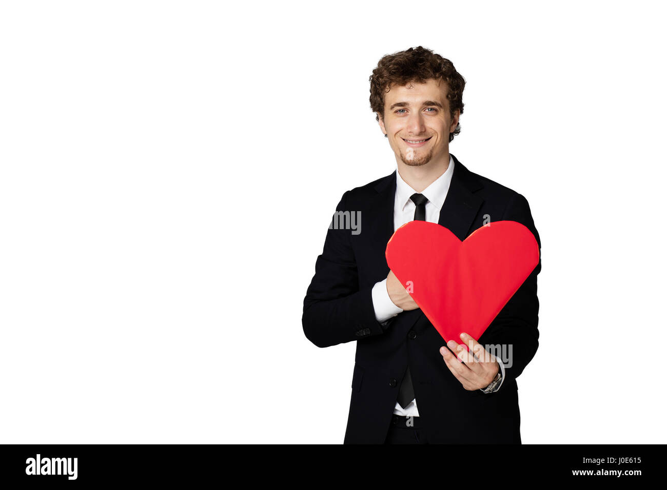 handsome curly man in elegant suit holding a heart in hands and smiling ...
