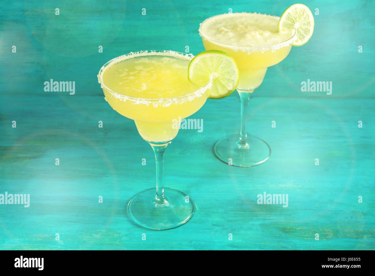 Lemon Margarita cocktails on vibrant teal with copyspace Stock Photo