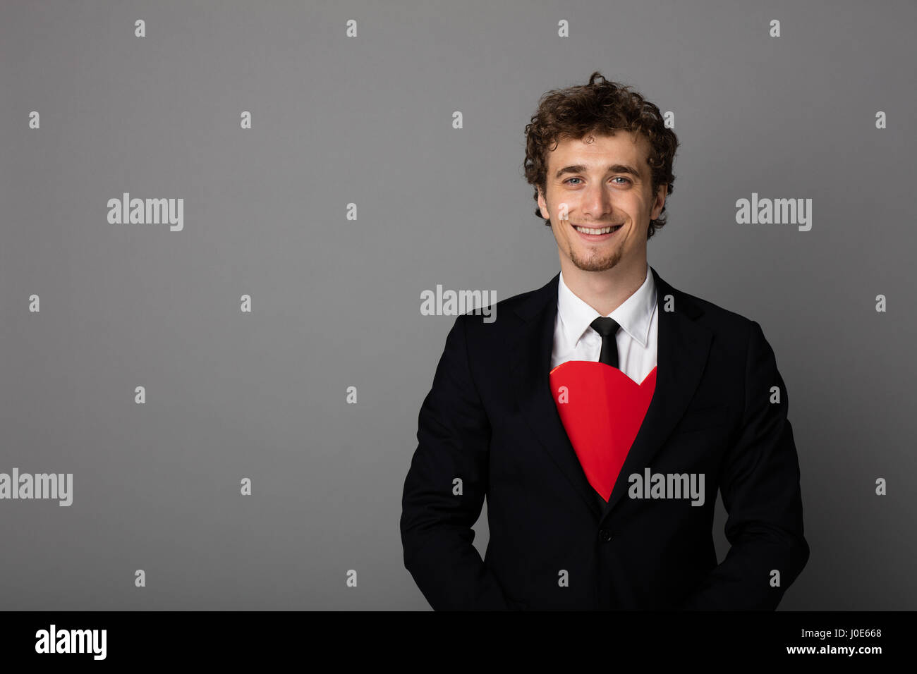 handsome elegant man in black suit having a red heart inside his suit ...