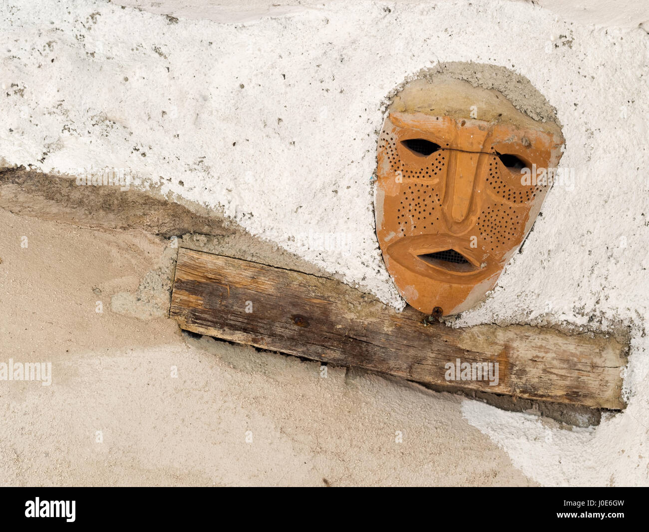 Terracotta mask set in ceiling. Stock Photo