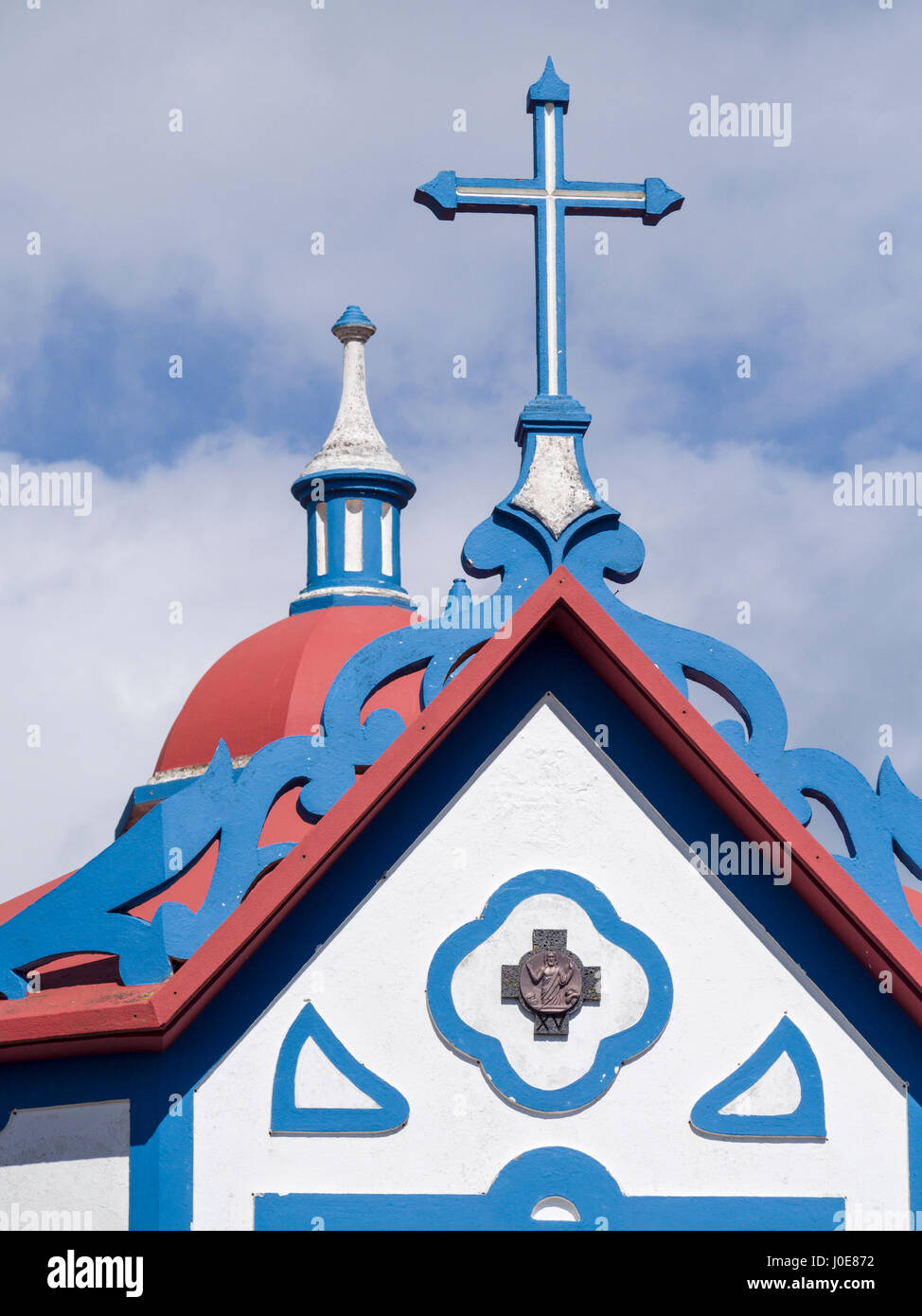 Detail from the Nossa Senhora do Monte Chapel. A cross, a dome and a spire decorate this small chapel high above teh town of Agua De Pau. Rua do Pico  Stock Photo