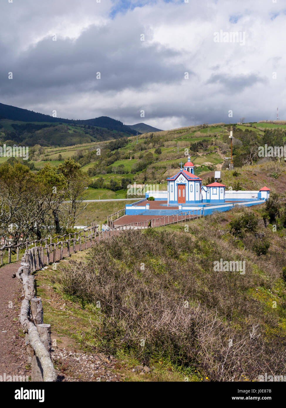 The Path to Nossa Senhora do Monte Chapel. A roughly fenced path leads to this famous shrine, sited high above the town and lit by the afternoon sun.  Stock Photo
