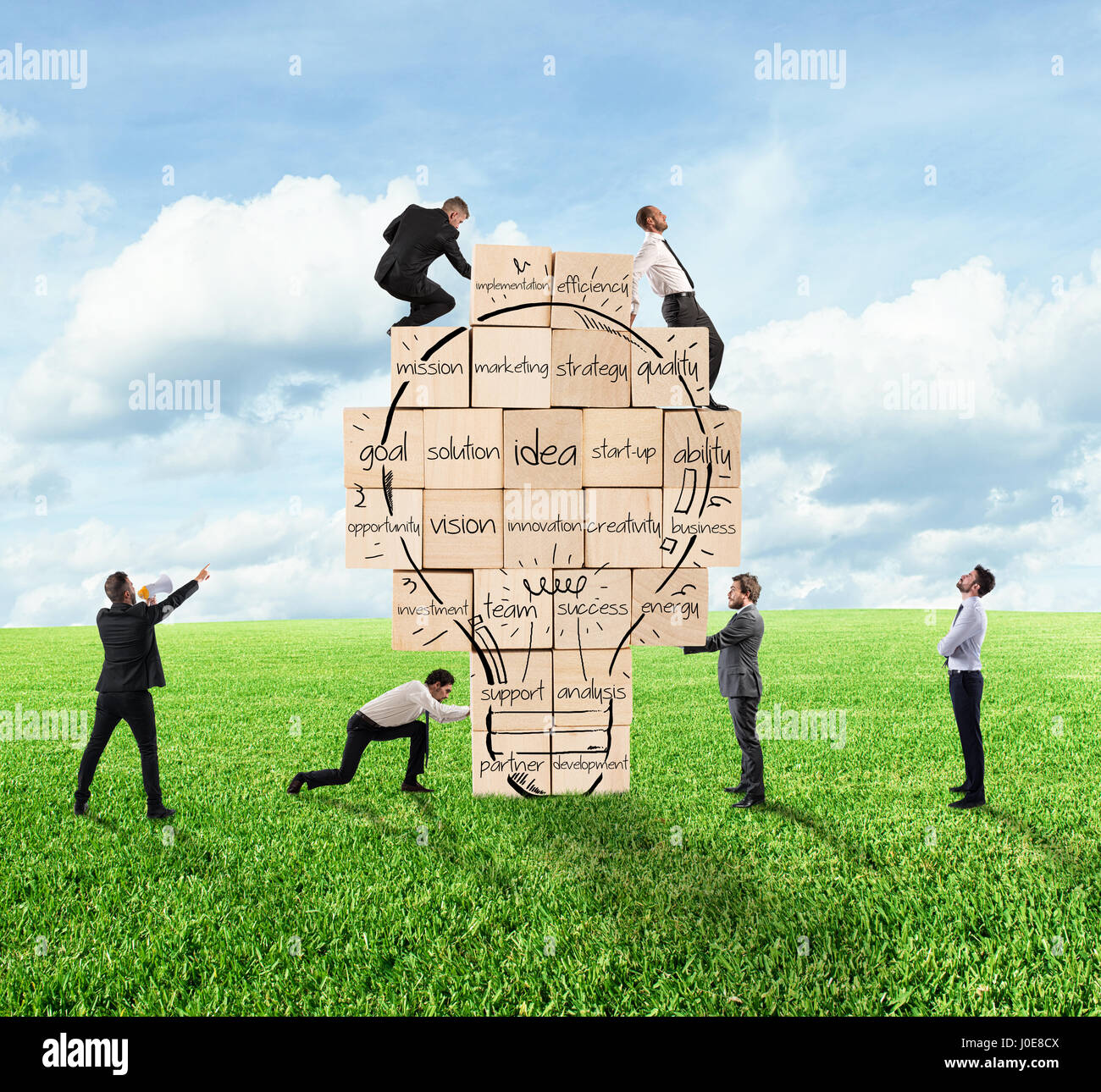 Building a new creative idea. Business person built together a big brick wall with drawn lightbulb Stock Photo