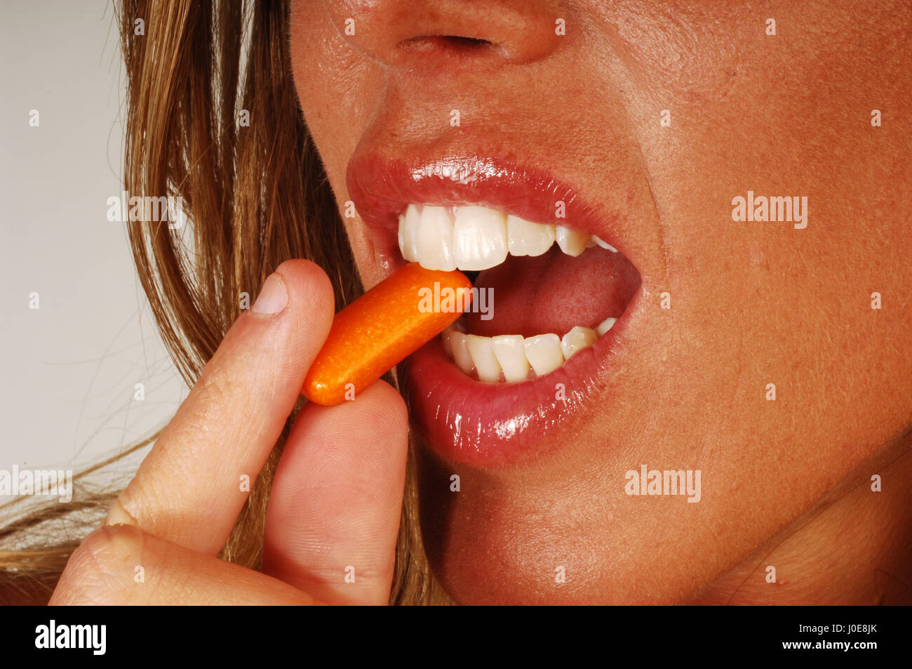 Woman eat with bubble gum on her face Stock Photo