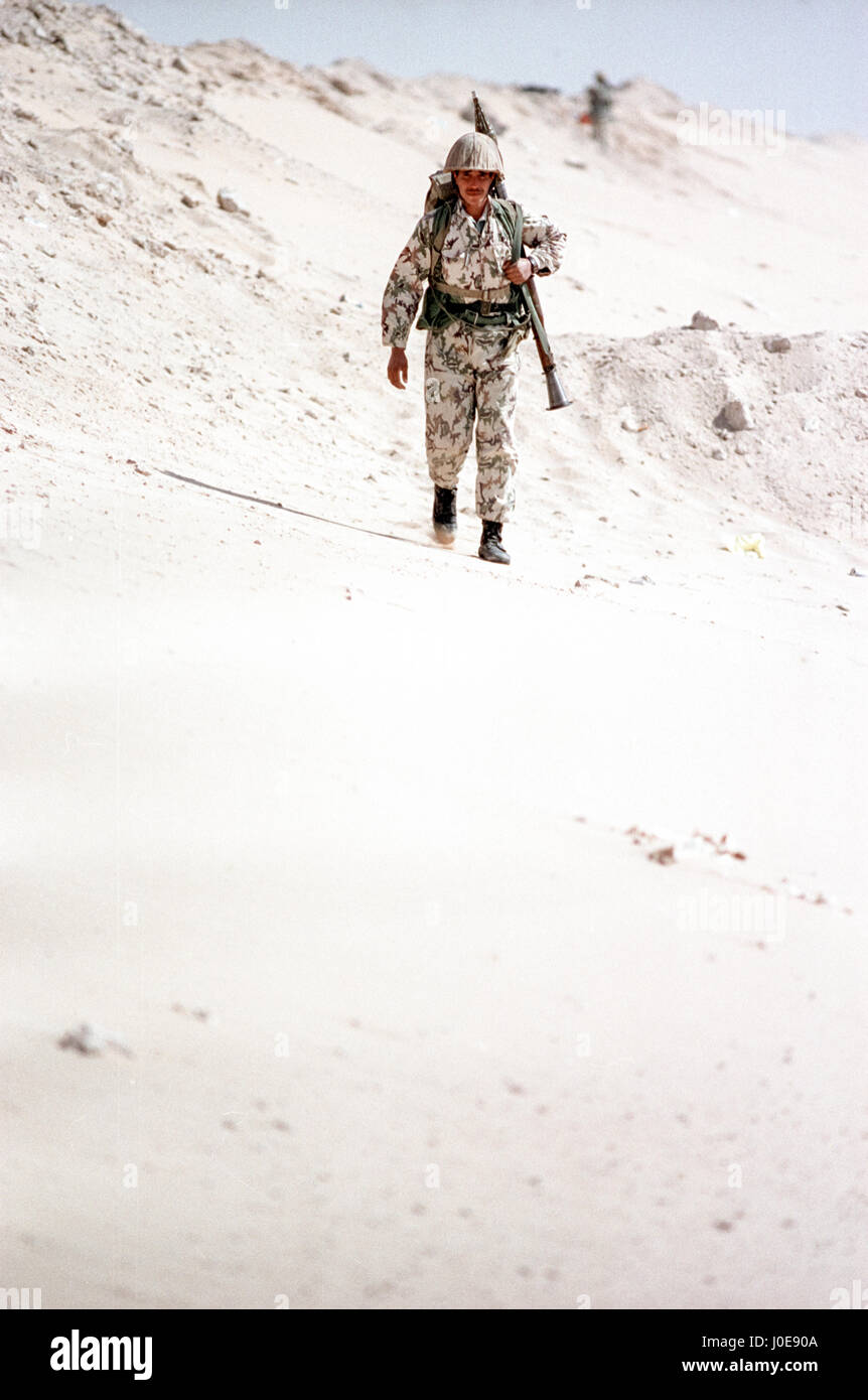 An Egyptian soldier patrols the sand berm marking the border of Kuwait and Saudi Arabia with a rocket-propelled grenade February 8, 1991 in Ruqa, Saudi Arabia. Egyptian soldiers are part of the coalition of nations in Operation Desert Storm to liberate Kuwait from Iraqi occupation. Stock Photo