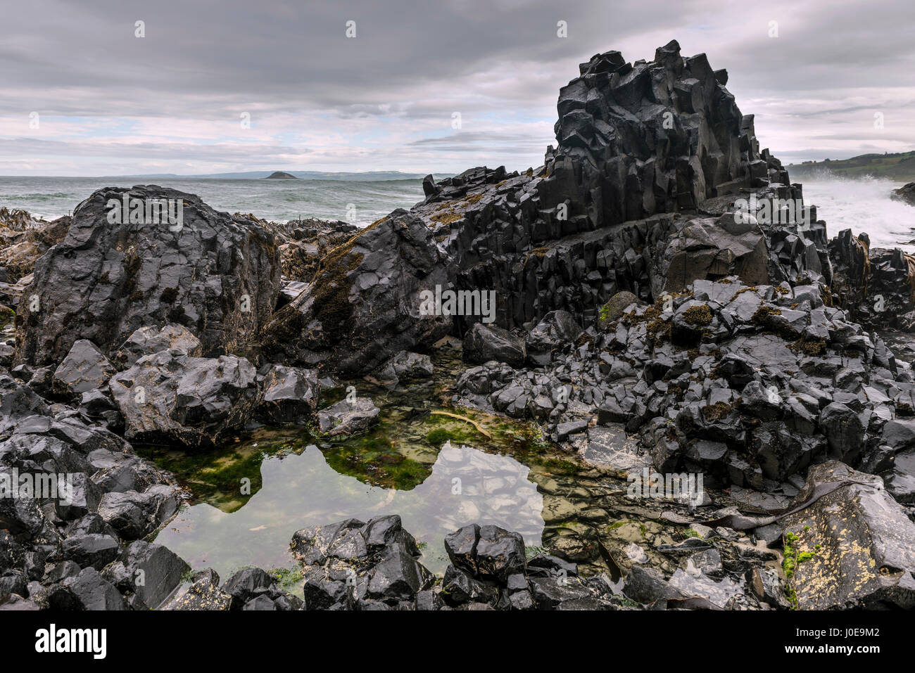 Black basalt rock by the sea, Blackhead, Dunedin, Otago, Southland, New Zealand Stock Photo