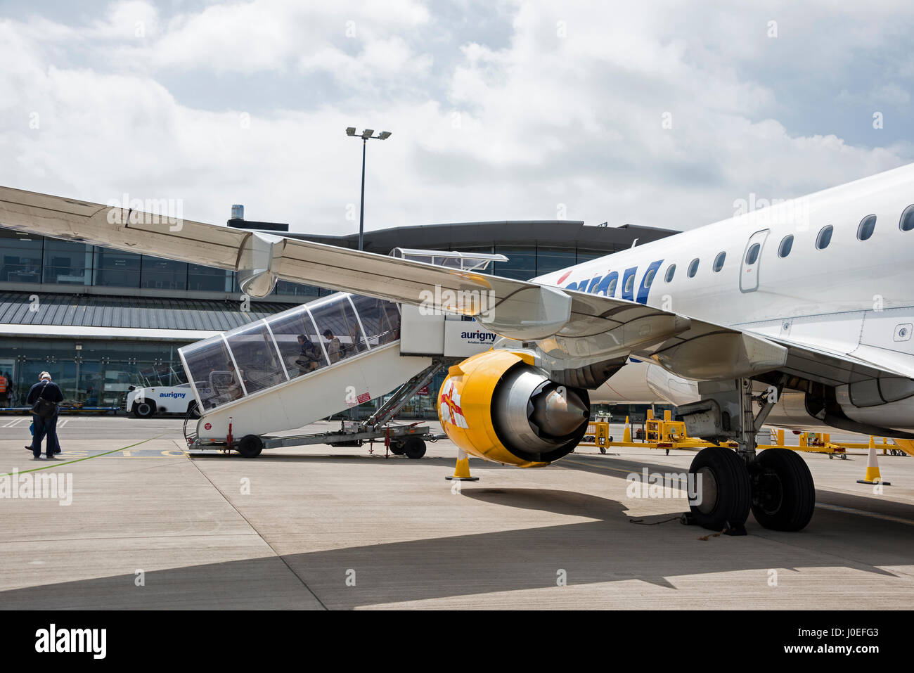 Passengers disembarking at Guernsey airport from an Aurigny aircraft in the Channel Islands.   The aircraft serving Gatwick and Guernsey is a Brazilia Stock Photo