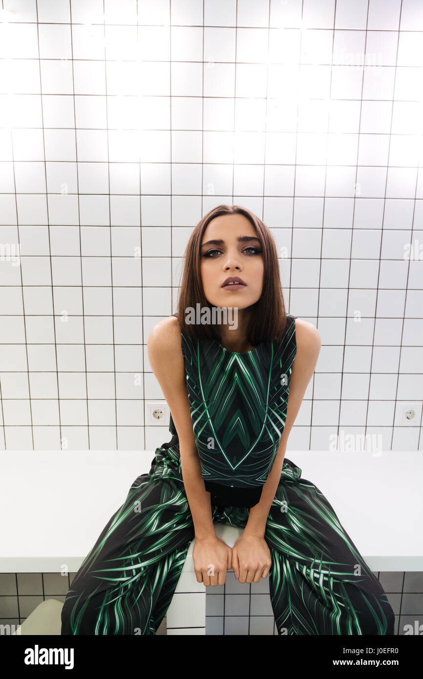 Portrait of pretty young woman sitting on table at indoor cafe Stock ...