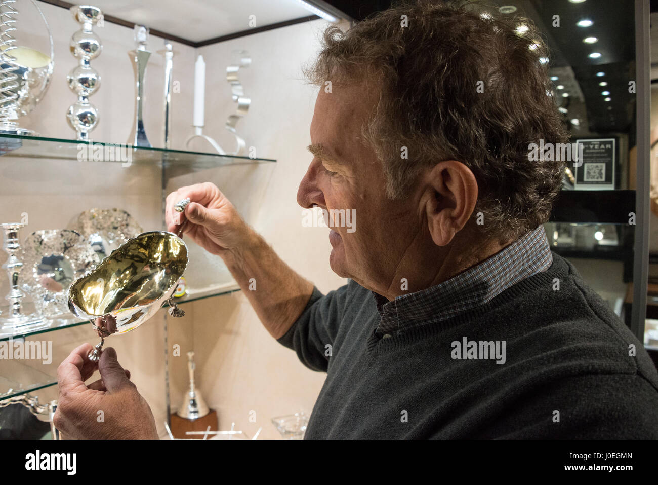 Holding a silver plated hand crafted sauce boat in his showroom is Bruce Russell at Le Gron in St. Saviours in Guernsey in the Channel Islands, Britai Stock Photo