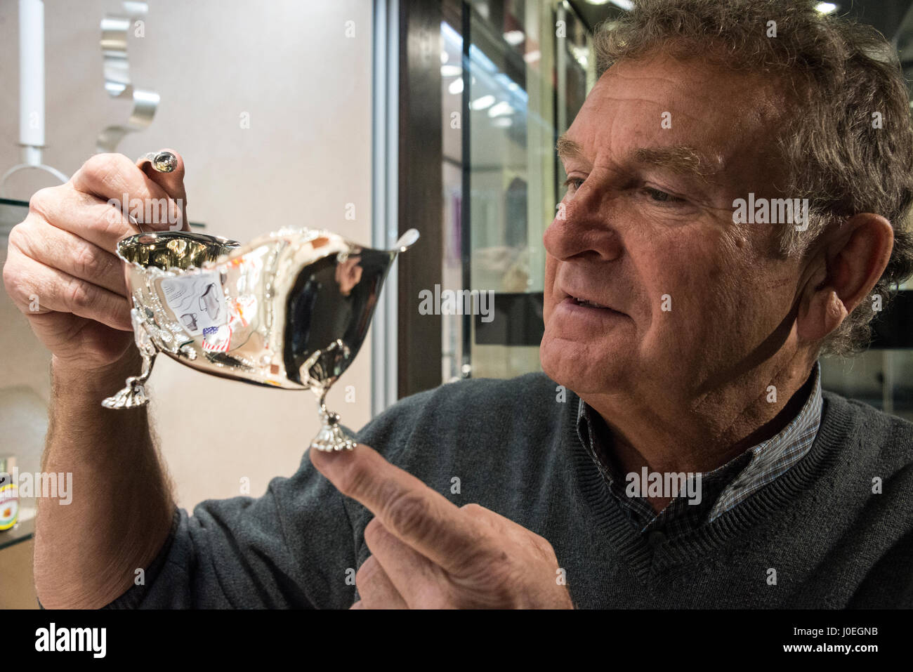Holding a silver plated hand crafted sauce boat in his showroom is Bruce Russell at Le Gron in St. Saviours in Guernsey in the Channel Islands, Britai Stock Photo