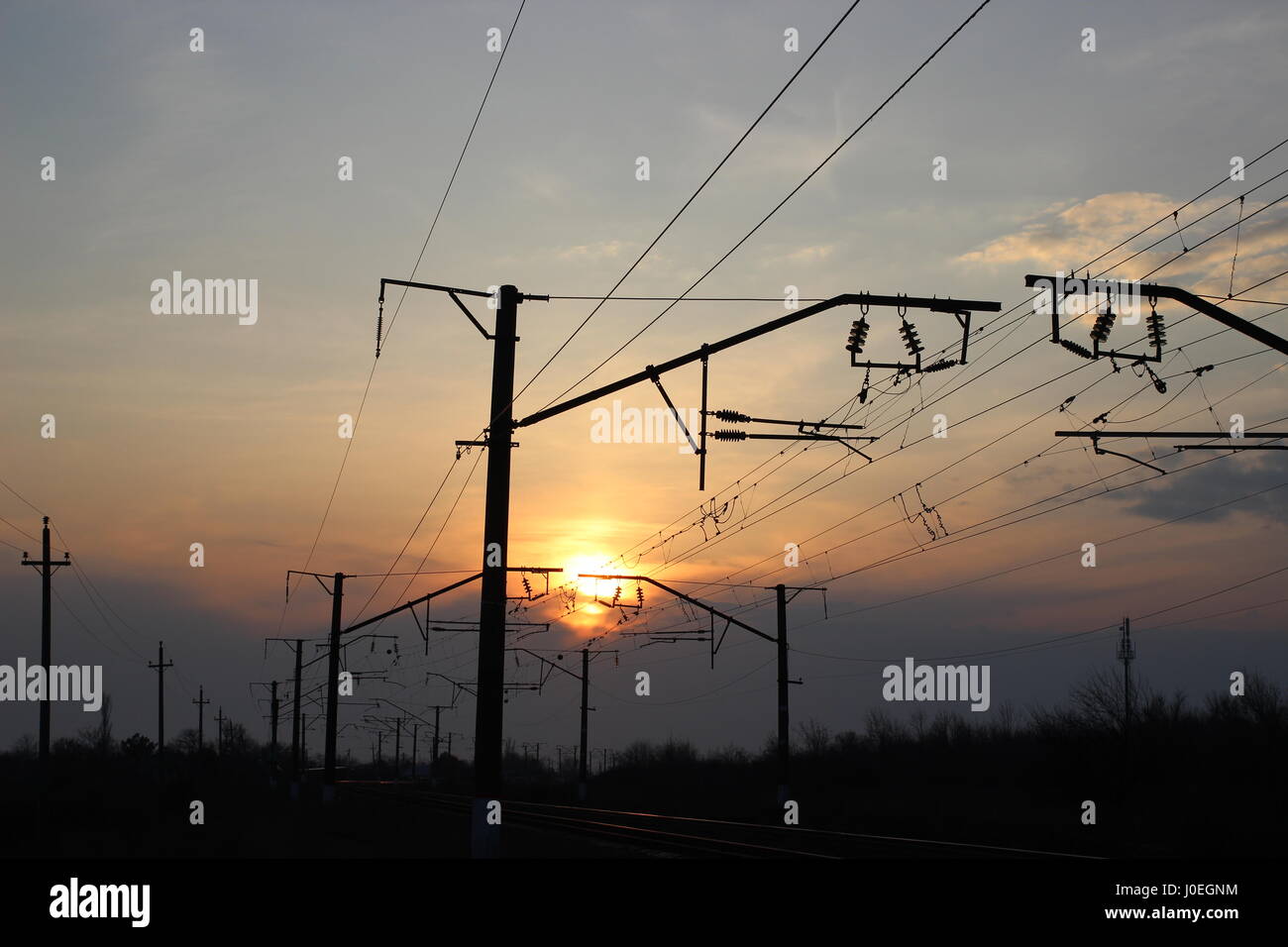 Wires over the railway at sunset. Evening and twilight Stock Photo