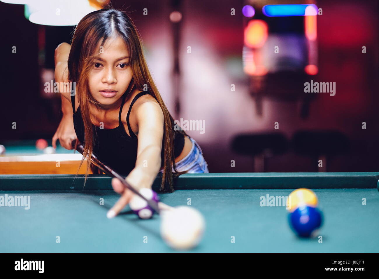 Young beautiful girl playing billiard in a club Stock Photo