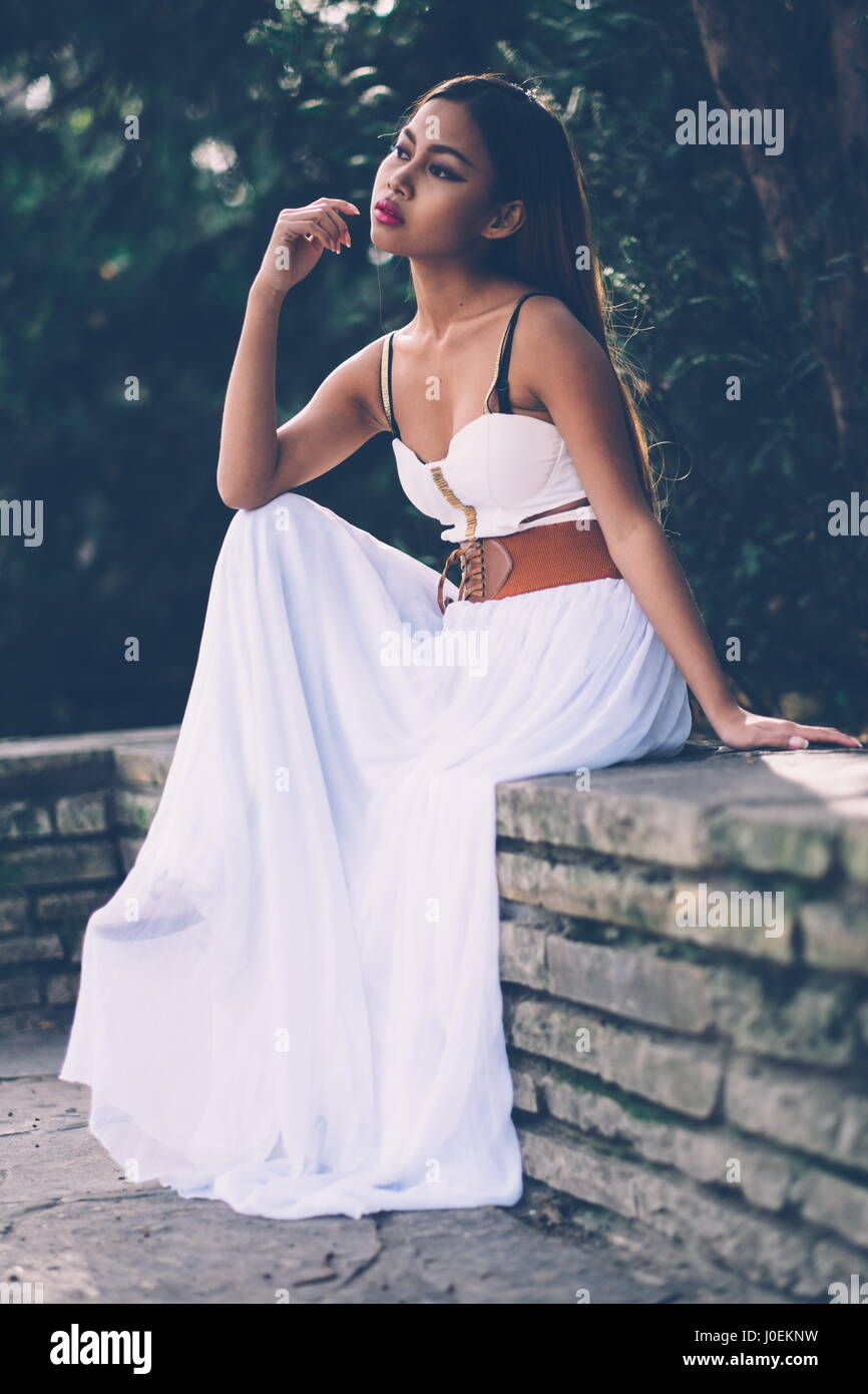 Beautifull girl in long white dress sitting, posing in the park Stock Photo  - Alamy