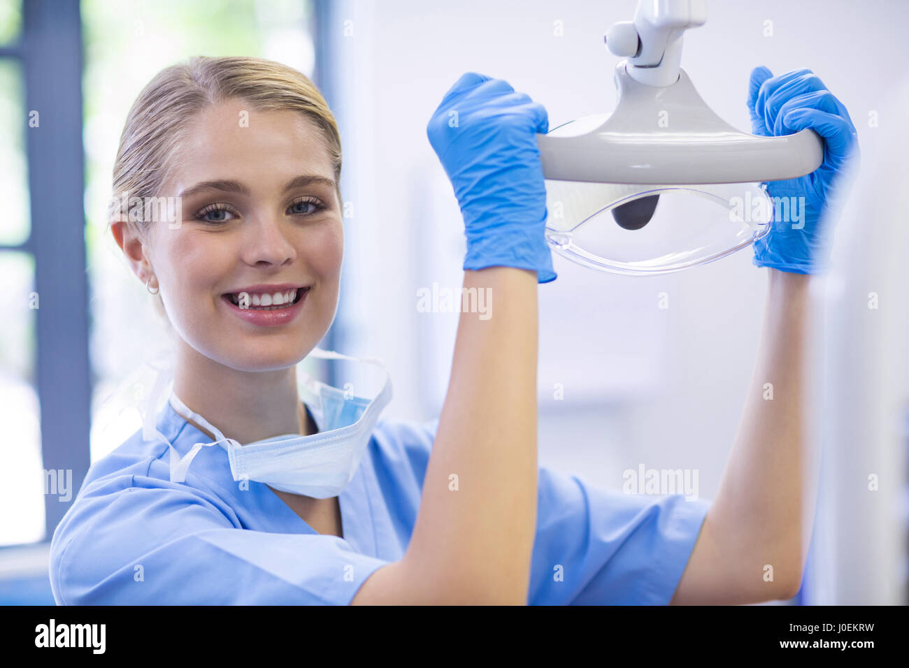Portrait of female nurse adjusting dental light in clinic Stock Photo