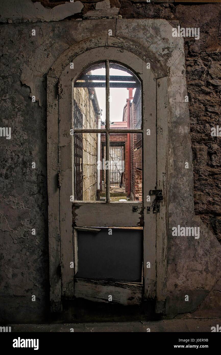 A decaying door with broken windows at the abandoned Eastern State Penitentiary in Philadelphia, Pennsylvania. Stock Photo