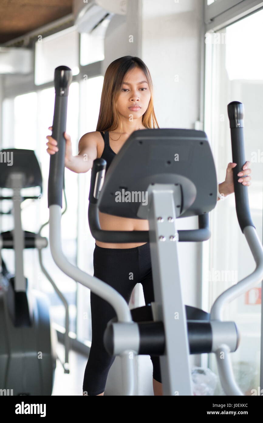 Young petite woman exercising on ski machine in the gym Stock Photo - Alamy