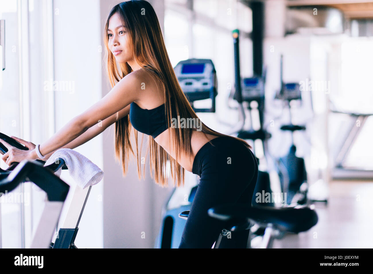 Sport young woman on a stationary bike in the gym Stock Photo