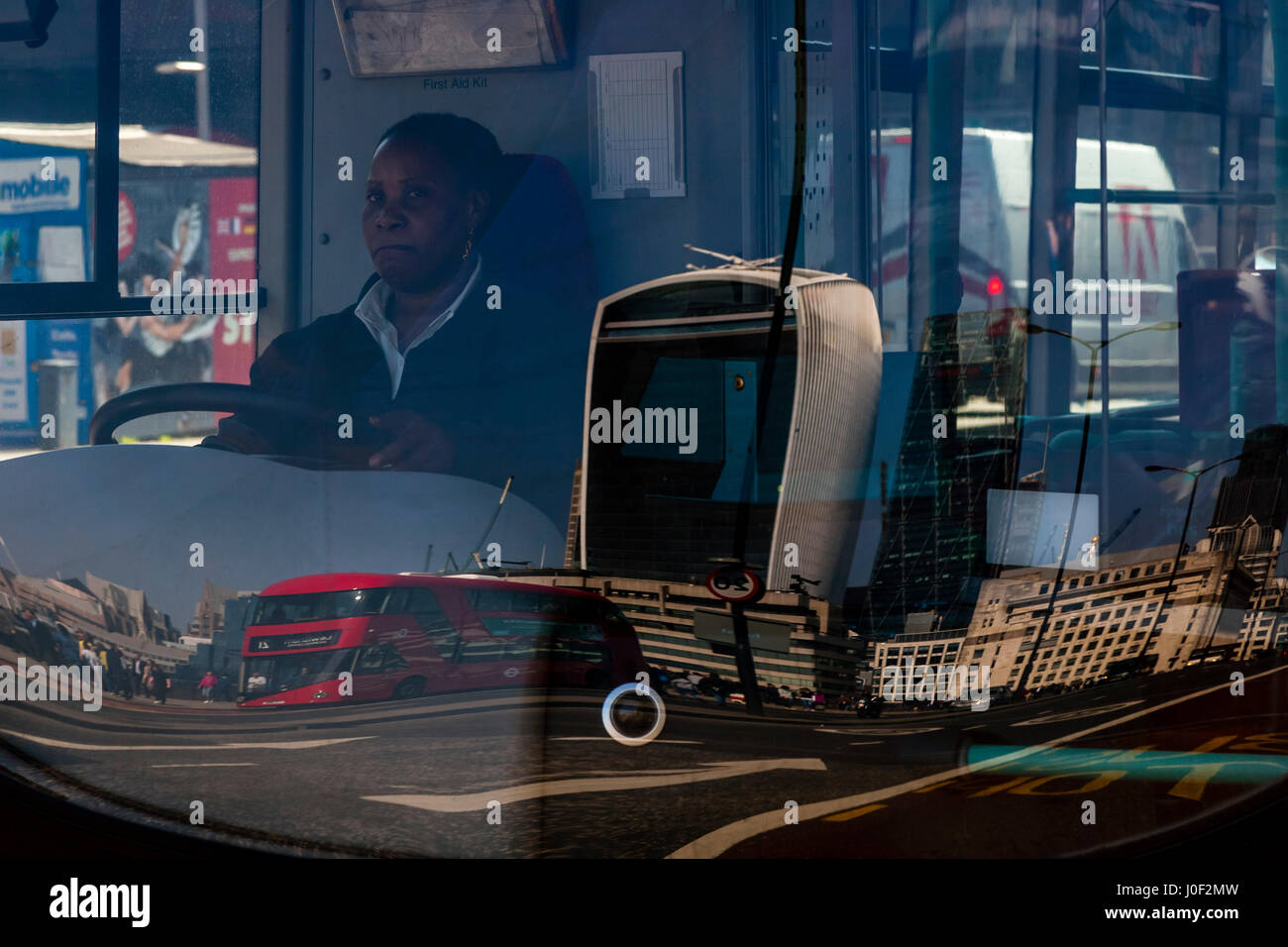 Reflections Of Iconic Buildings On The Front Window Of A Red London Bus, London, England Stock Photo