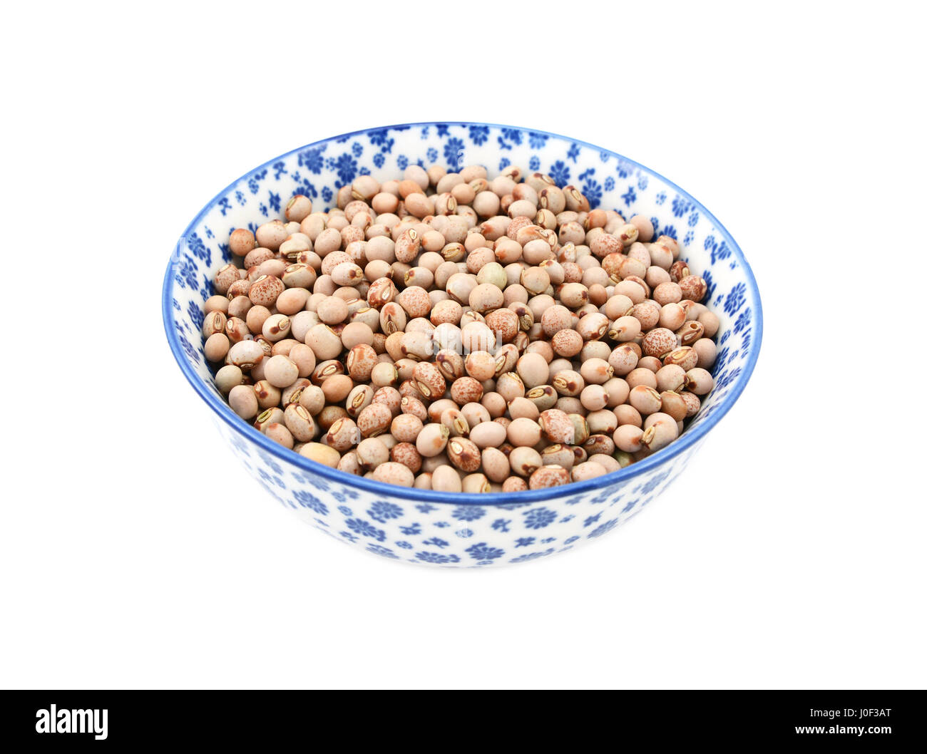 Pigeon peas in a blue and white porcelain bowl with a floral design, isolated on a white background Stock Photo