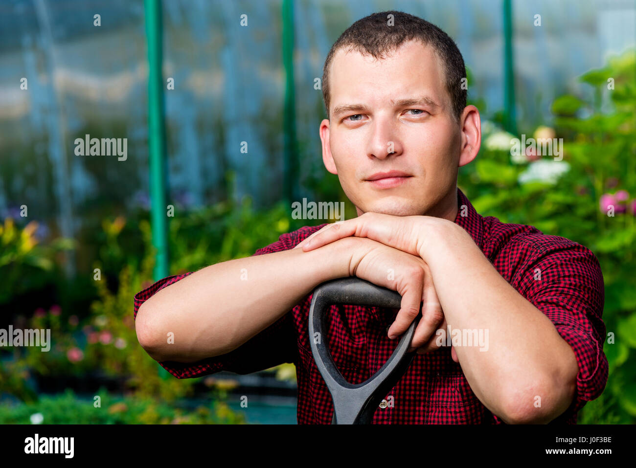 Portrait of a man with a shovel in the greenhouse Stock Photo - Alamy