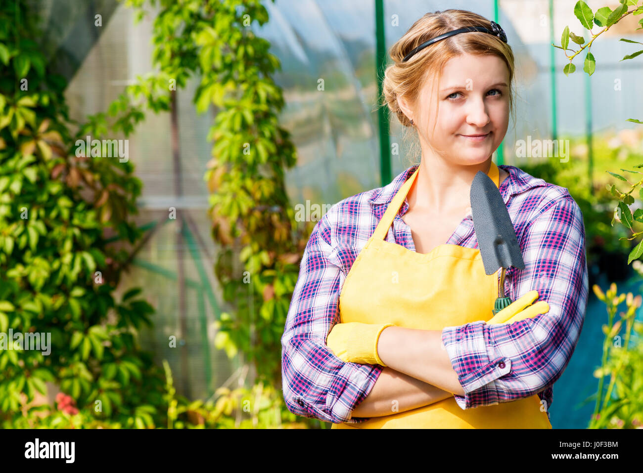 Beautiful young girl working in a greenhouse gardener Stock Photo - Alamy