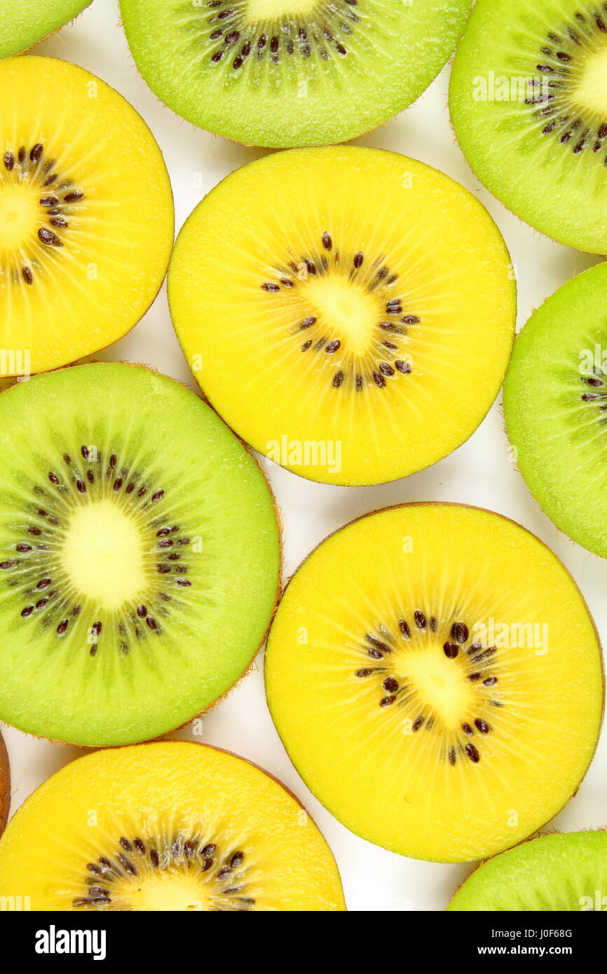 slices of fresh green and yellow kiwi fruits as a food background texture Stock Photo