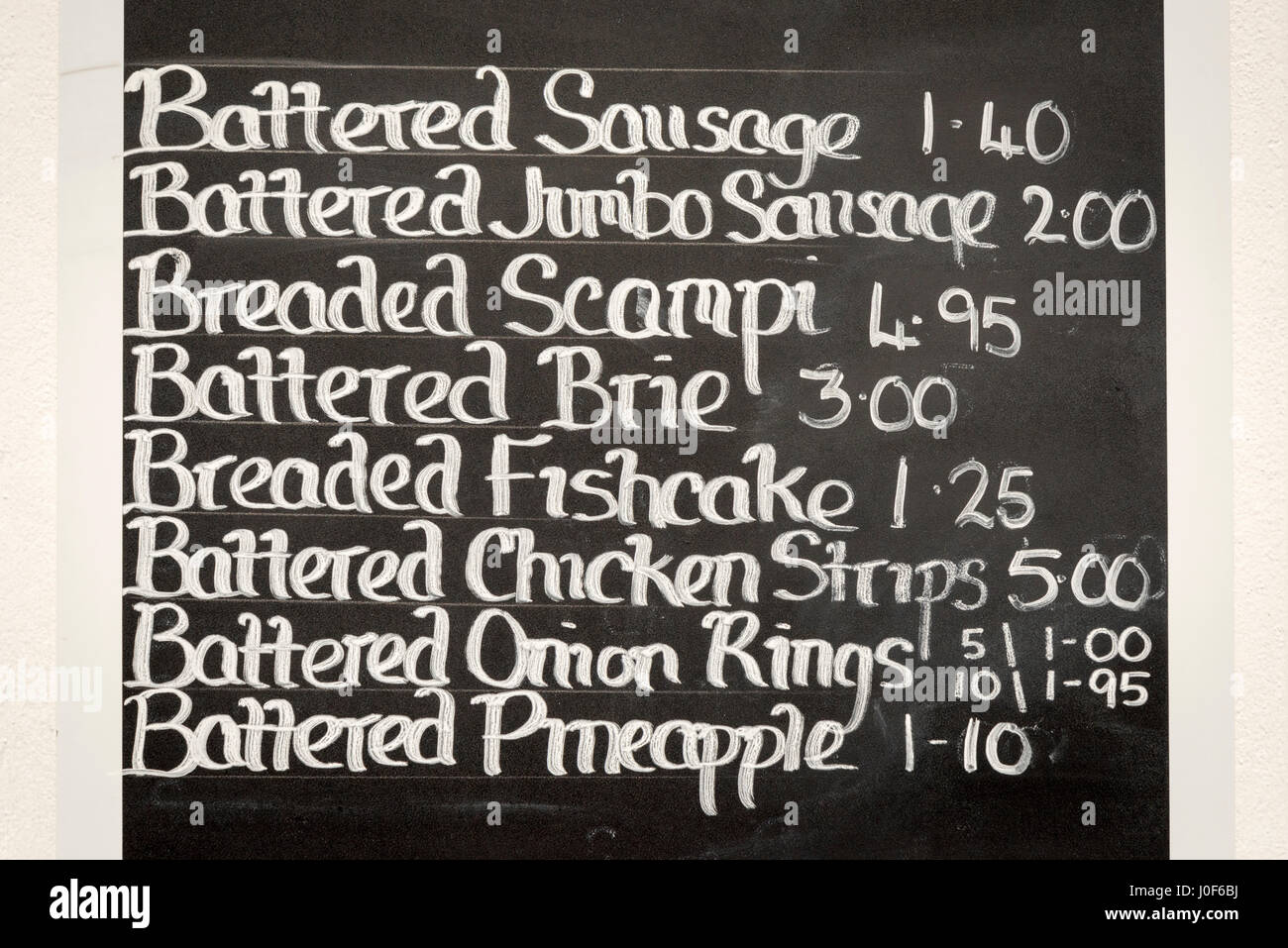 A fish and chip shop menu written in chalk on a blackboard Stock Photo