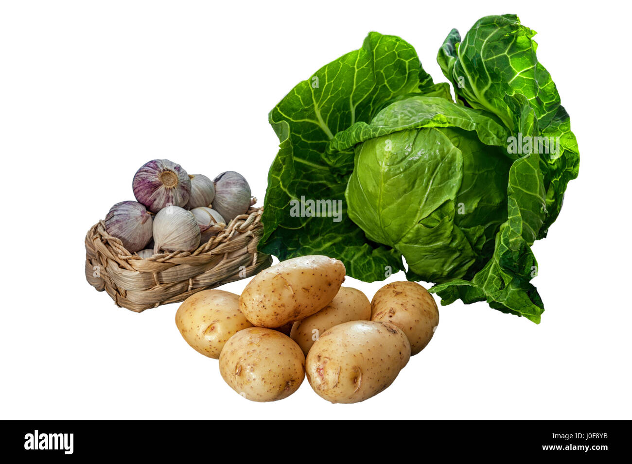 young early harvest potato, garlic in a basket and fresh young cabbage