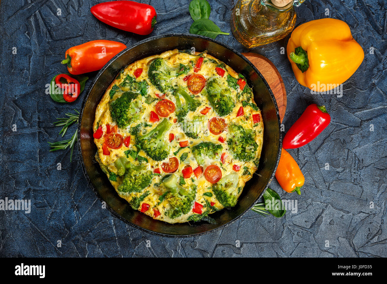Frittata with broccoli, spinach, sweet peppers and tomatoes in iron