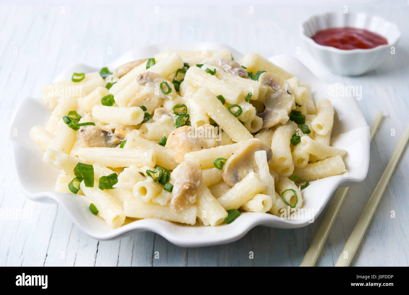 Macaroni pasta with onions and  mushrooms on a plate Stock Photo