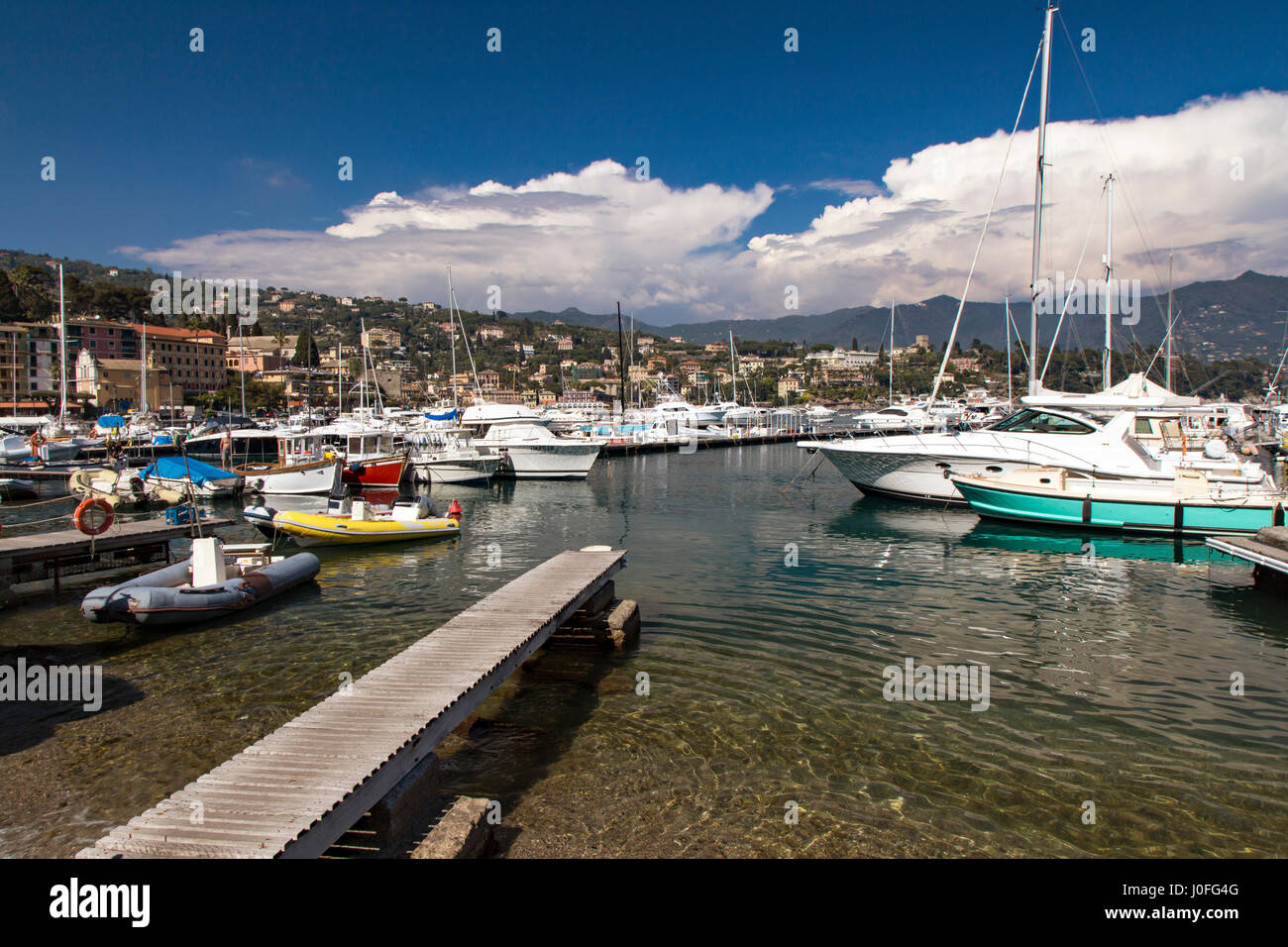 Boats moored in a sheltered marina in Santa Margherita Ligure, Liguria, Genoa , Italy a popular tourist destination in a scenic landscape under a clou Stock Photo