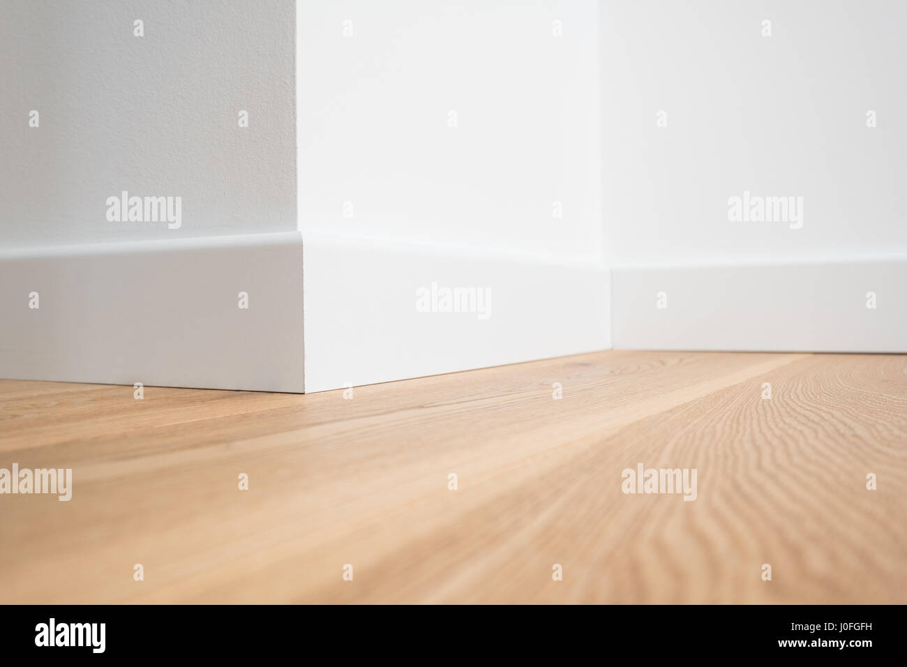wooden floor parquet and white walls closeup Stock Photo