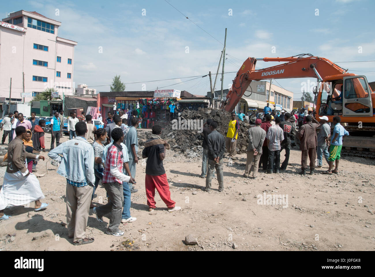 People observing the roadworks with digging machine in Addis Ababa Stock Photo