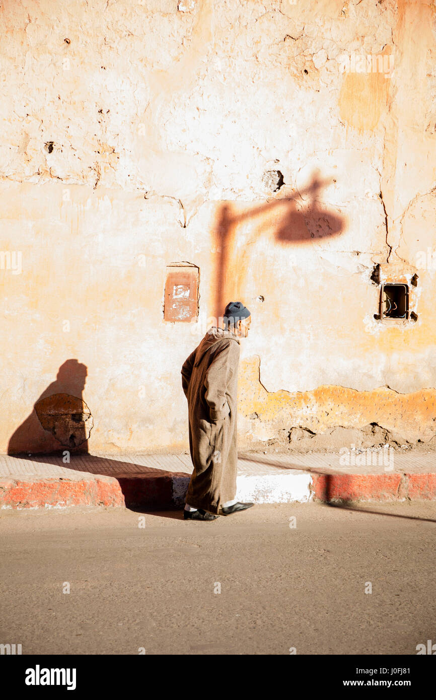 Moroccan man walking beneeth the sidewalk in Marrakesh Stock Photo