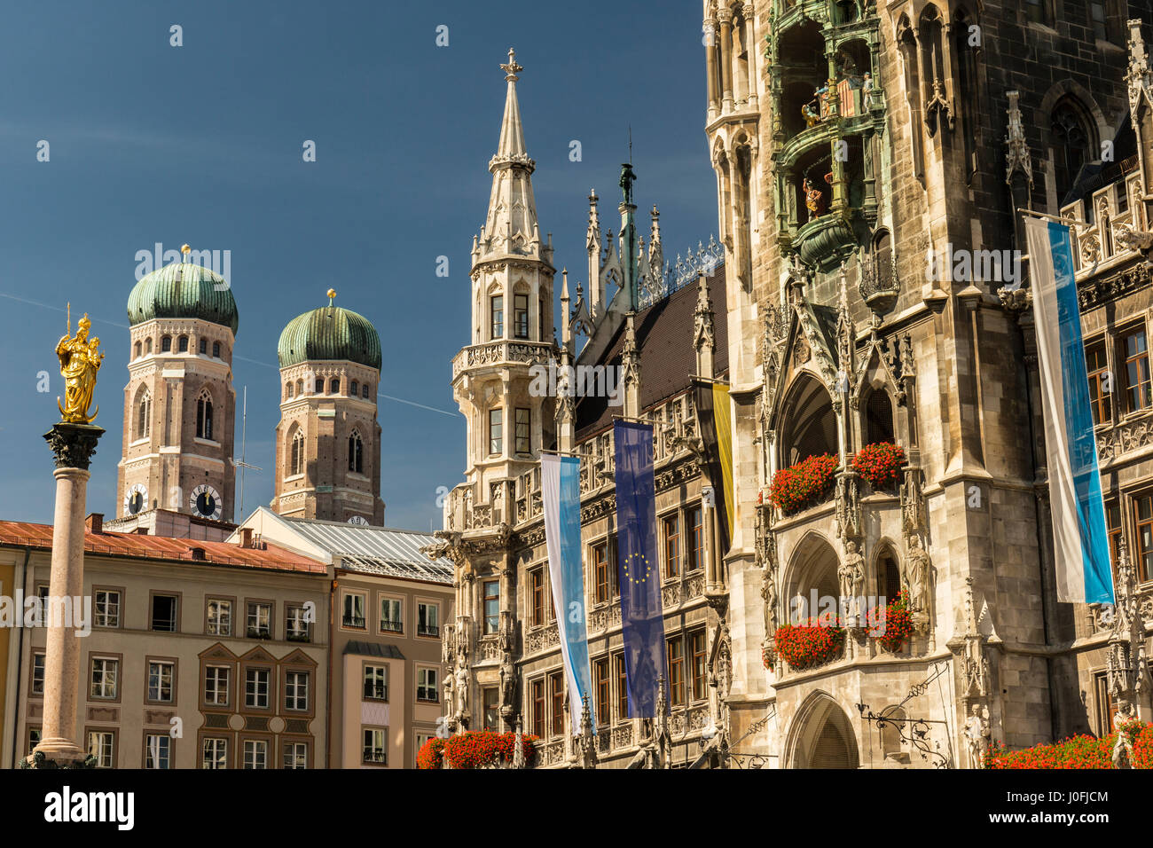 Detail of the town hall on Marienplatz with the statue of Virgin Mary. In the background, the mighty towers of church Frauenkirche. Stock Photo