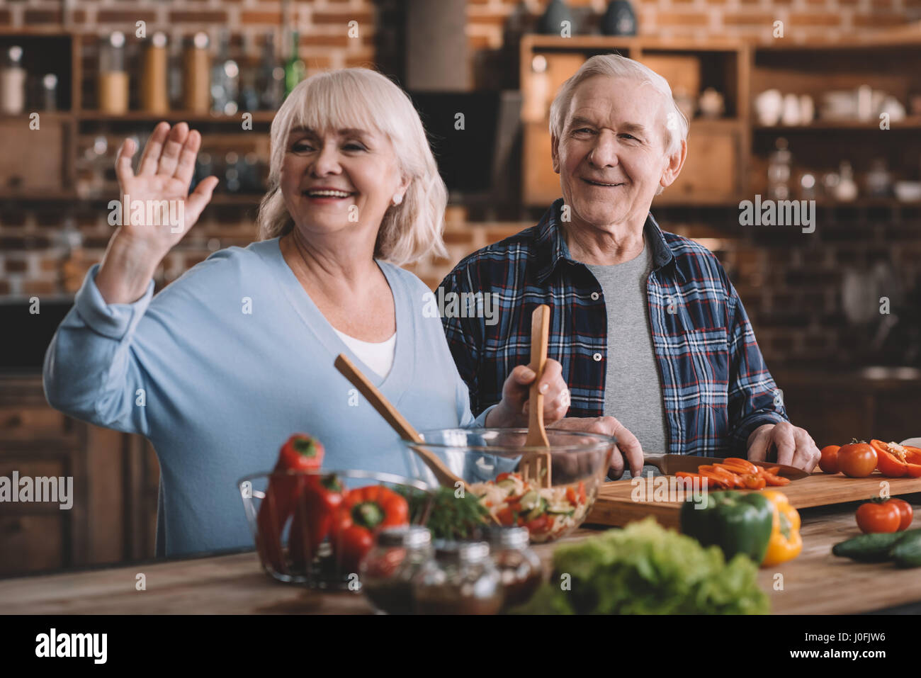 portrait of smiling senior couple making salad together Stock Photo