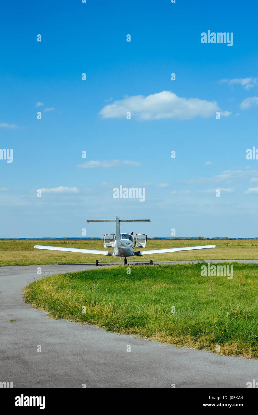 Small airplane on a takeoff airfield strip Stock Photo